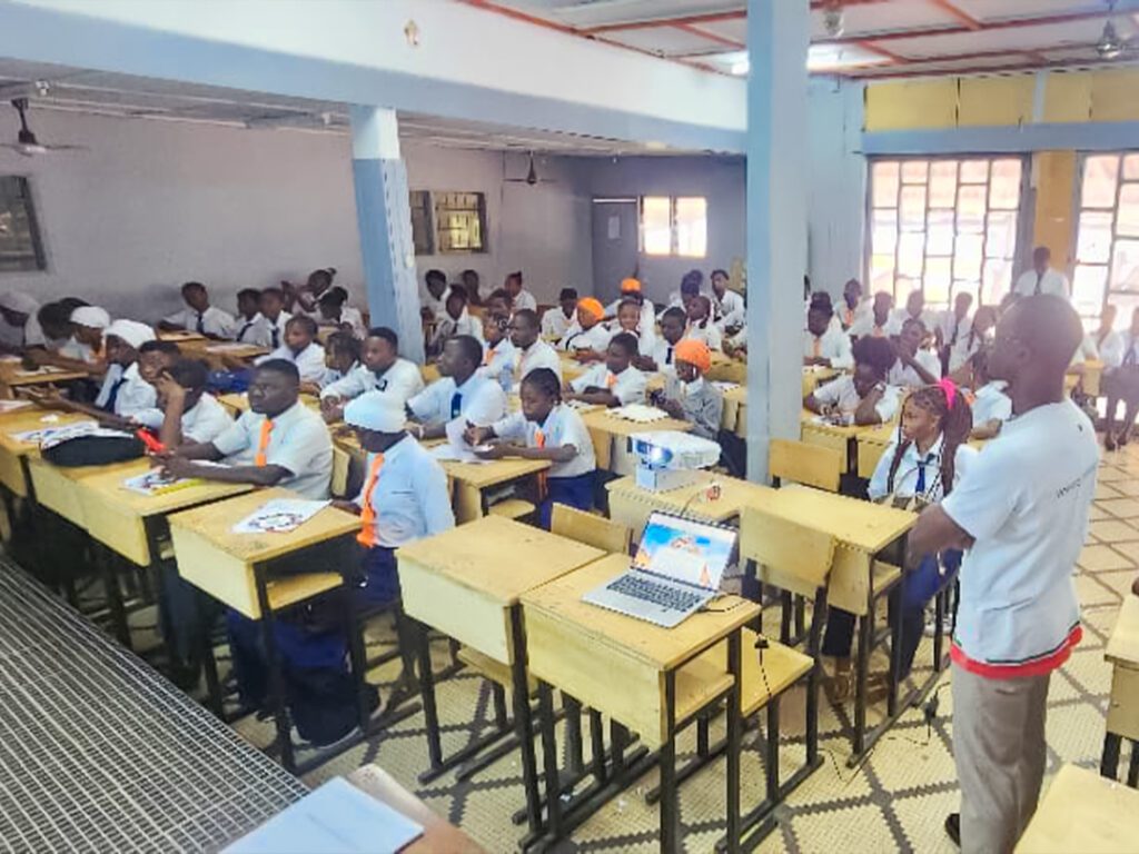 Groupe d'élèves en uniforme bleu et cravate rouge, posant avec plusieurs adultes devant un bâtiment blanc. Dans le cadre de son programme phare Africa DigiEmpower, THEYA by Cybastion a déployé du 24 au 27 mars 2026 une mission de formation d'envergure à San Pedro, formateurs et encadrants a sillonné les établissements de la ville pour offrir des formations gratuites et certifiantes aux étudiants et jeunes de la région-Africa DigiEmpower formations gratuites pour les jeunes. design by adambita237