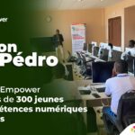 Groupe d'élèves en uniforme bleu et cravate rouge, posant avec plusieurs adultes devant un bâtiment blanc. Dans le cadre de son programme phare Africa DigiEmpower, THEYA by Cybastion a déployé du 24 au 27 mars 2026 une mission de formation d'envergure à San Pedro, formateurs et encadrants a sillonné les établissements de la ville pour offrir des formations gratuites et certifiantes aux étudiants et jeunes de la région-Africa DigiEmpower formations gratuites pour les jeunes. design by adambita237